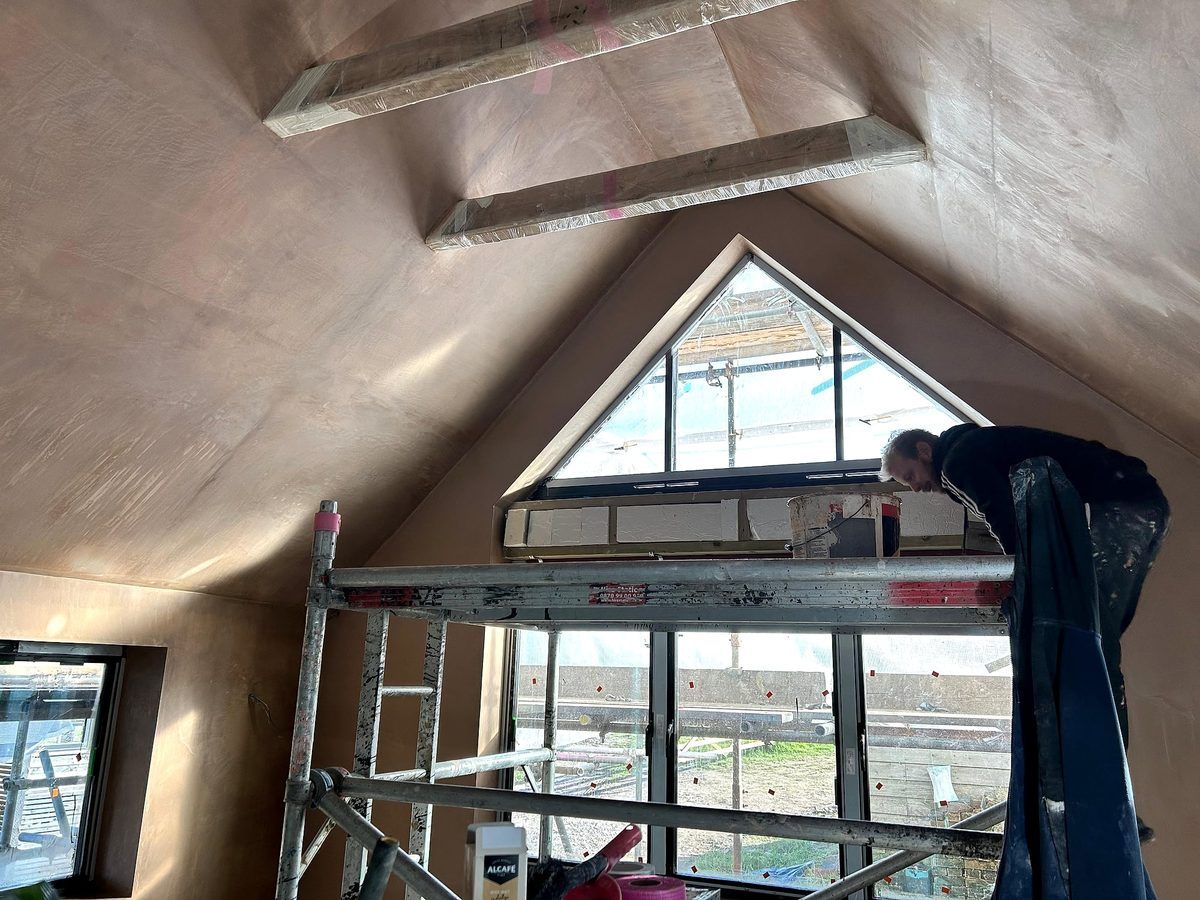 Basement room with plastered arched alcove fireplace and smooth skim coat on walls and ceiling in Kent
