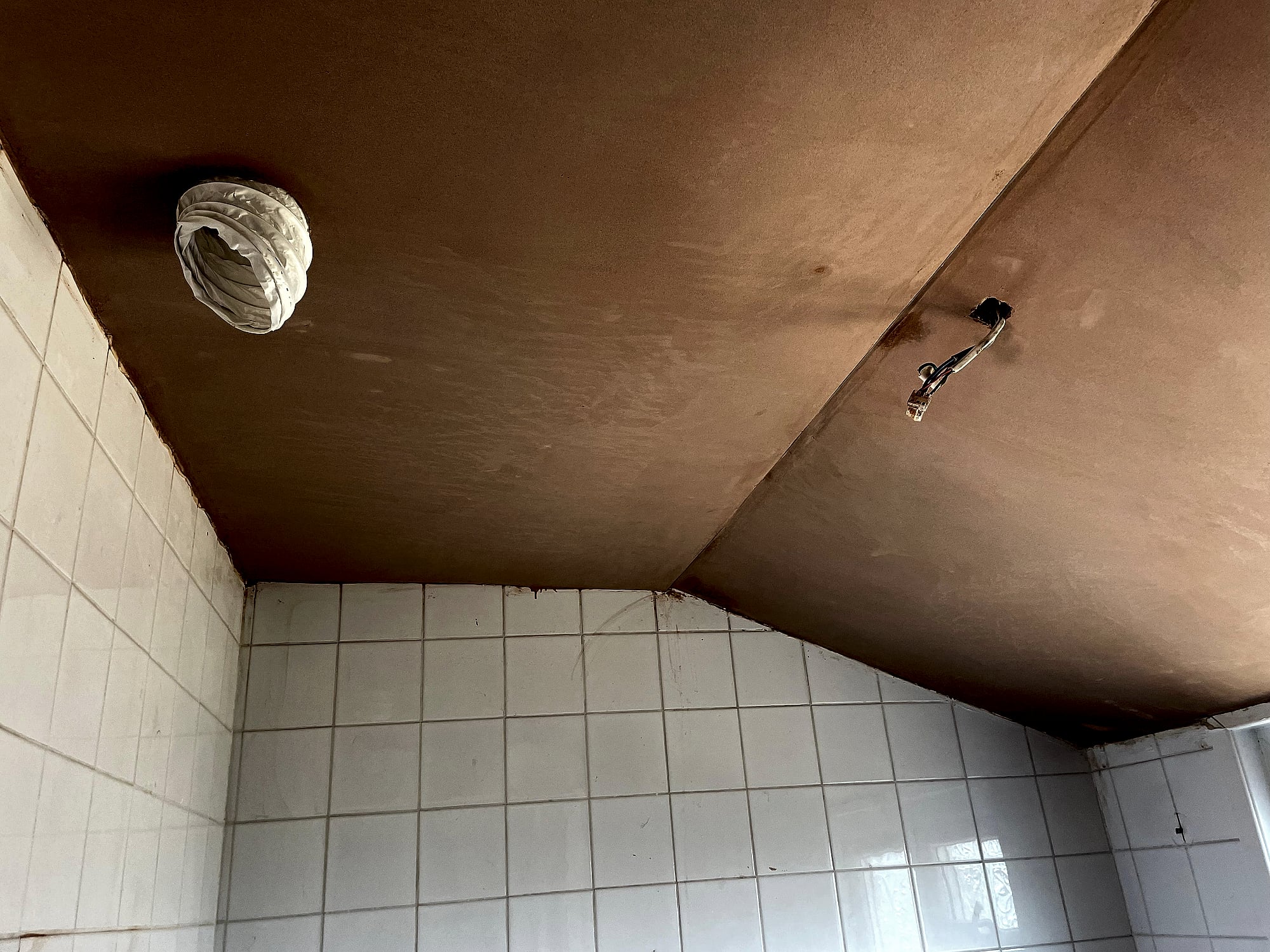 Bathroom ceiling freshly plastered with extractor fan opening and light fitting in Kent home renovation