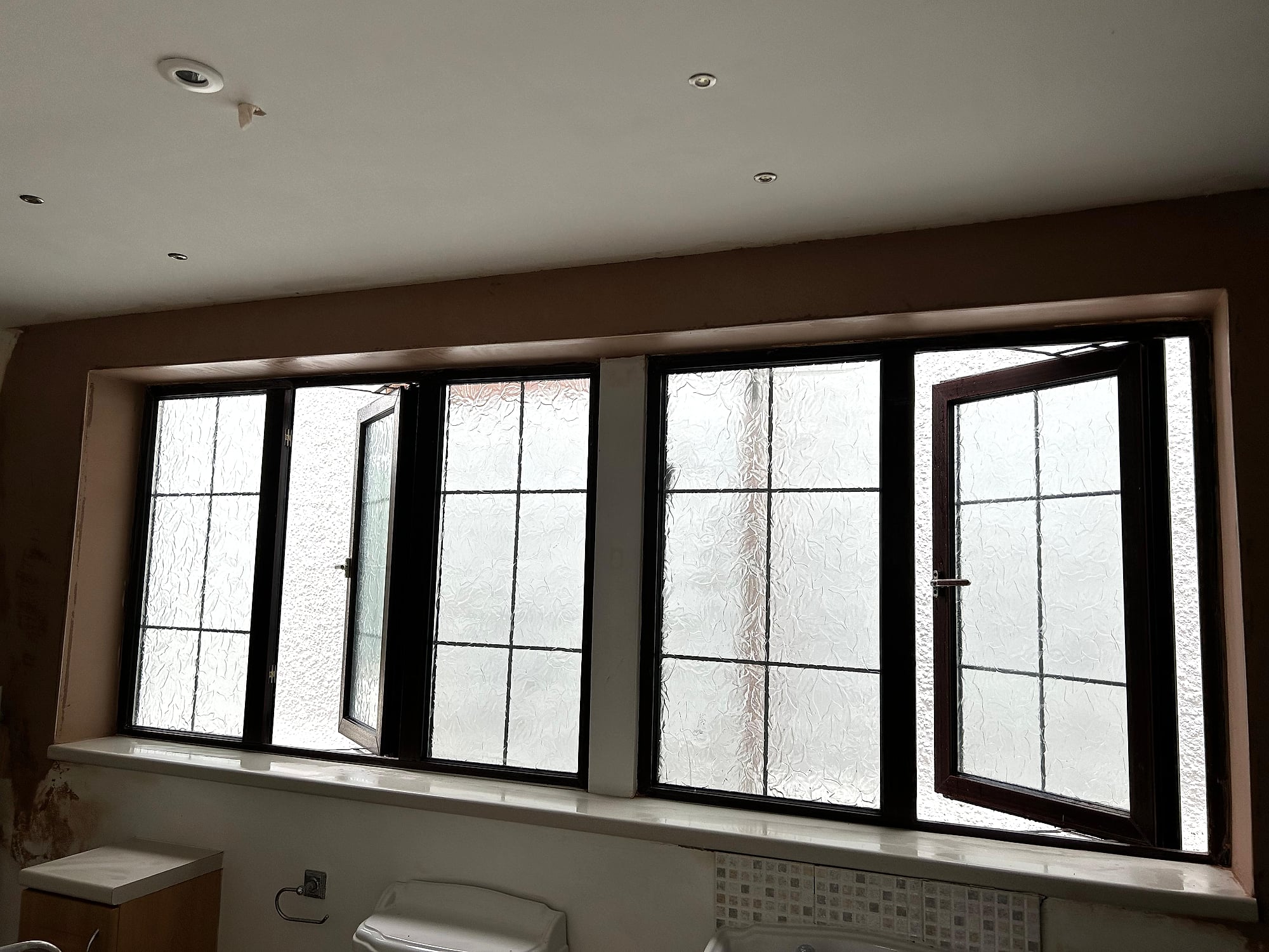 Bathroom with freshly plastered ceiling and triple frosted window reveal with downlights in Kent property