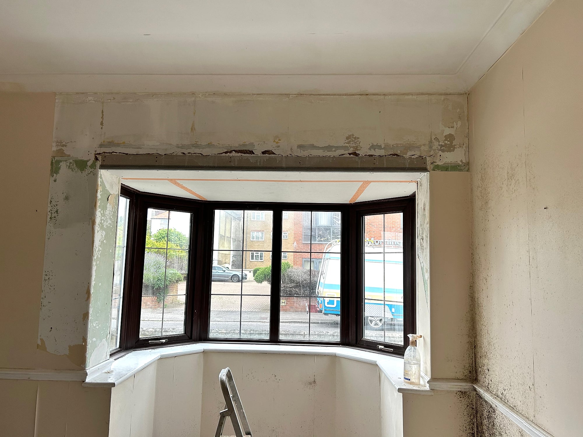Bay window reveal before plastering showing stripped walls and damp damage in Kent period property
