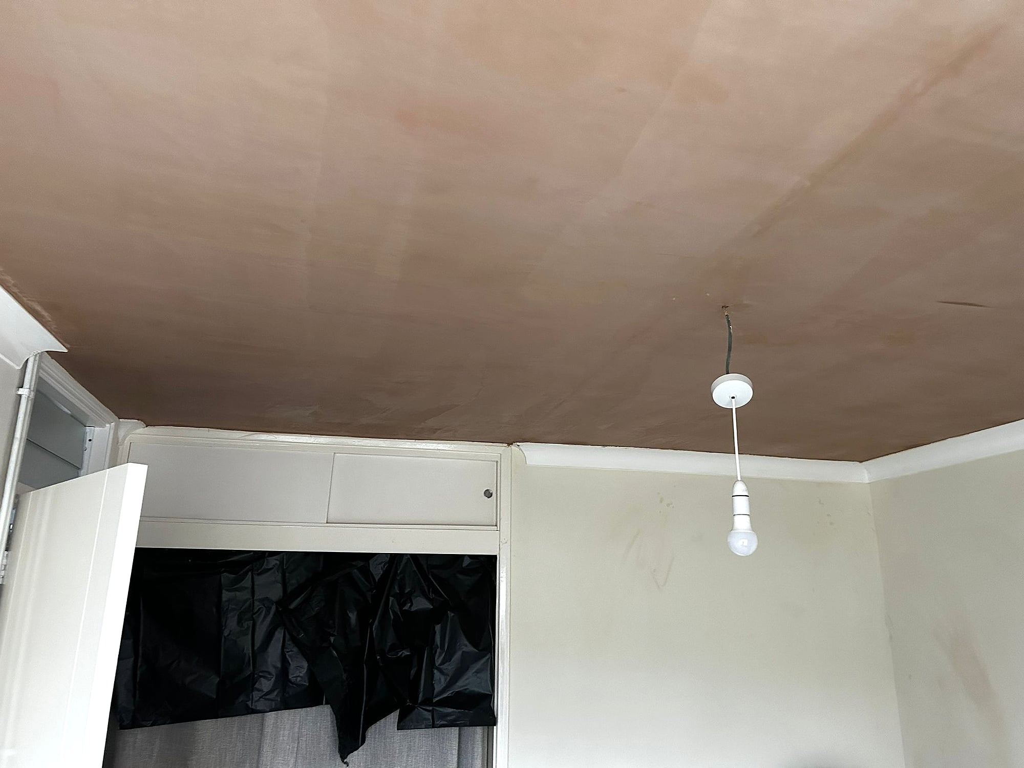 Bedroom with freshly skimmed ceiling and garden window showing smooth plaster ready for painting in Kent
