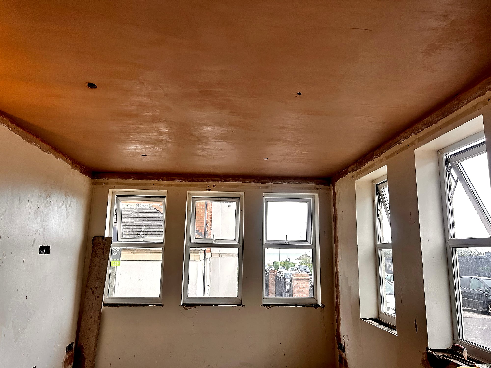 Narrow hallway before dry lining showing timber stud framework around window in Broadstairs period property