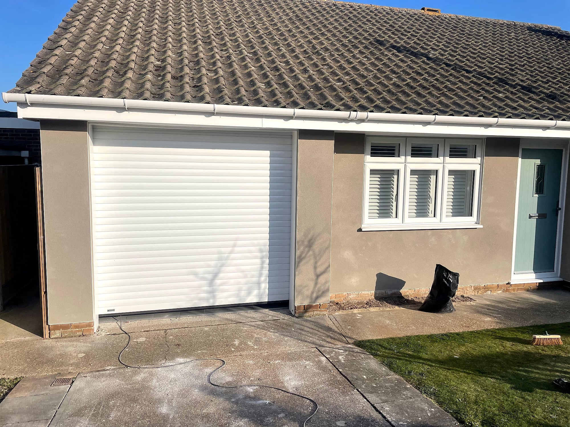 Completed monocouche render on bungalow front elevation with shuttered windows in Kent