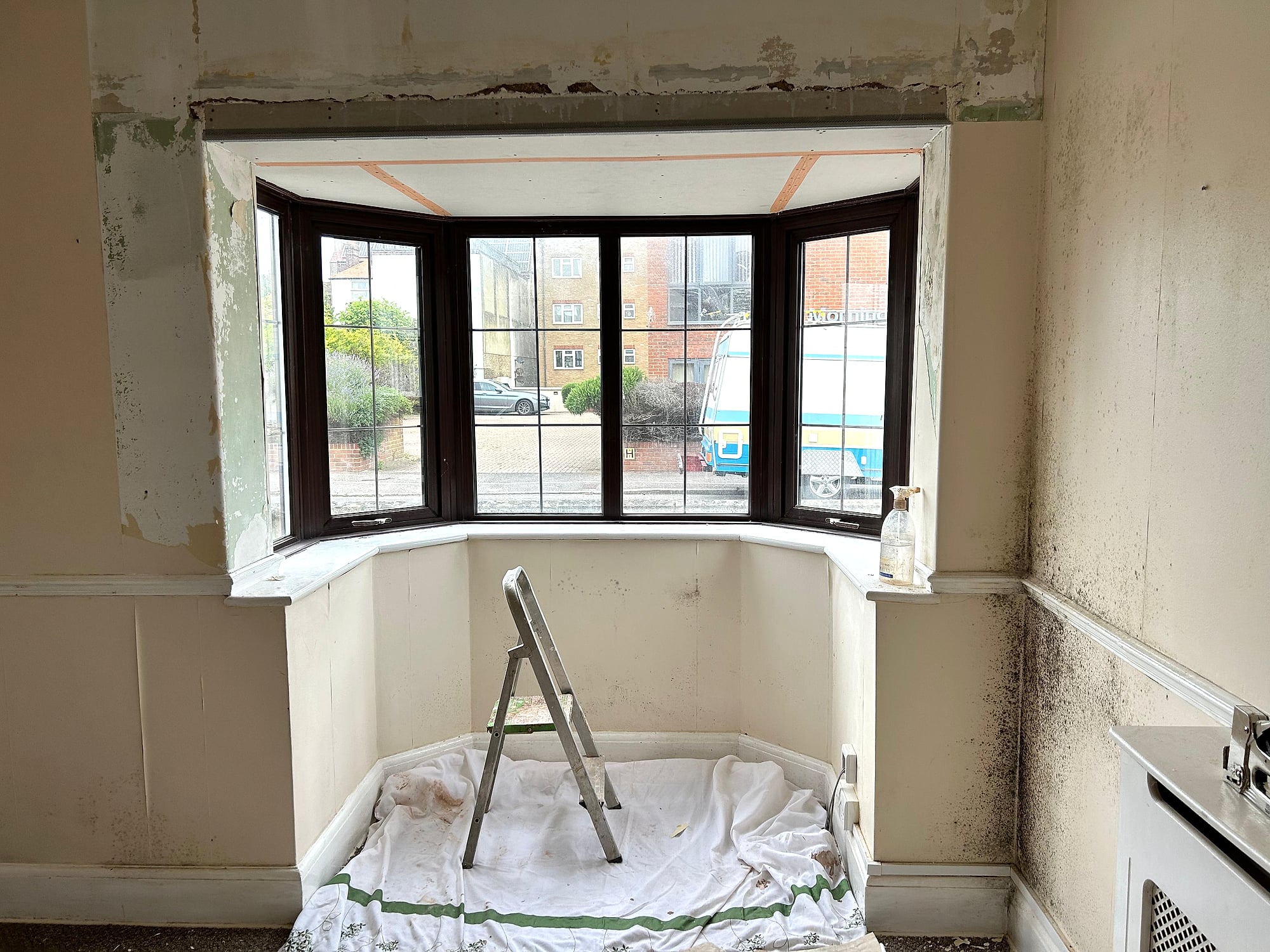 Large room ceiling freshly skimmed with pink fire-rated plasterboard and steel beam casing in Kent extension