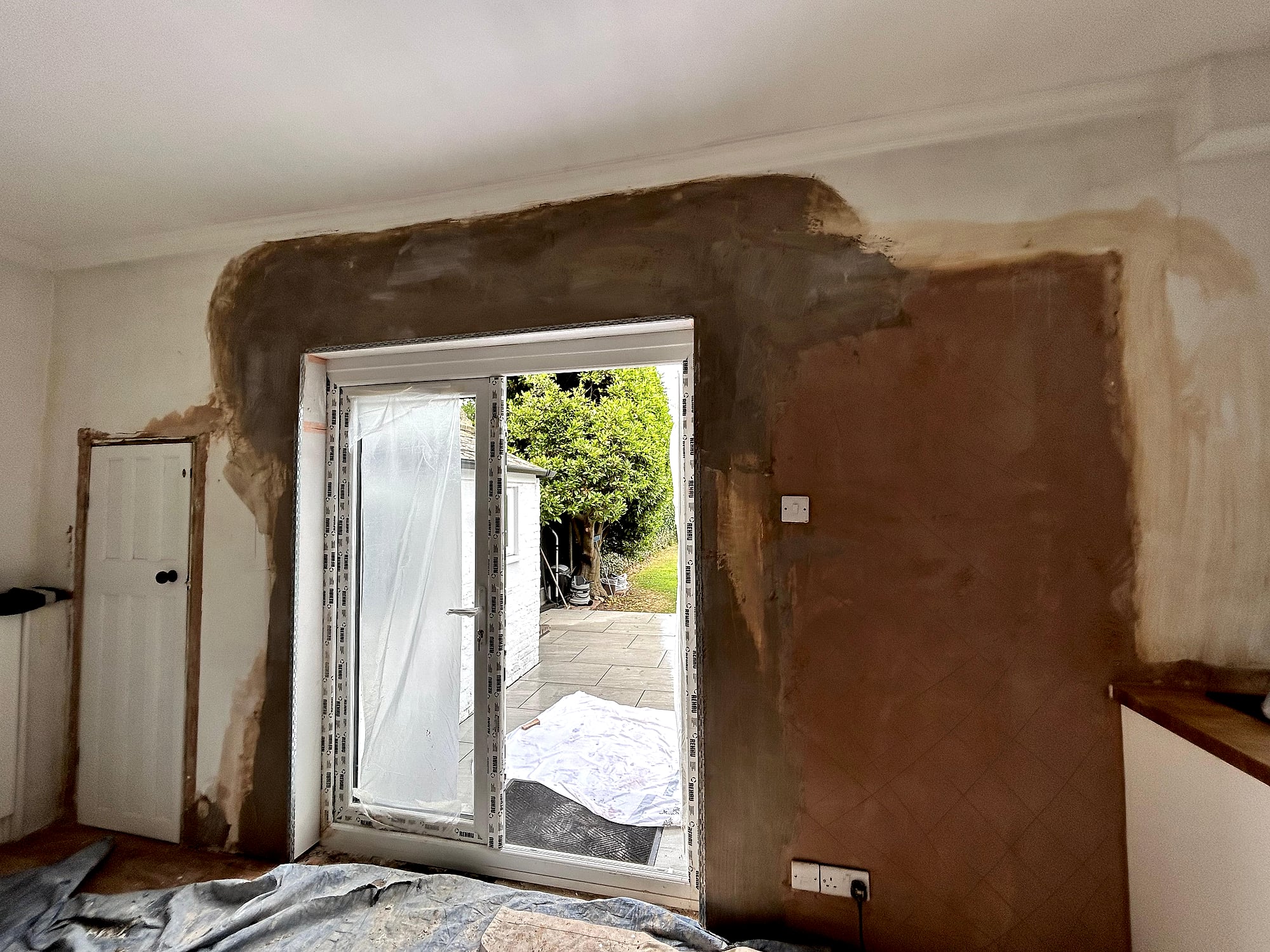 Freshly skimmed ceiling with corner windows showing smooth plaster finish in Kent property