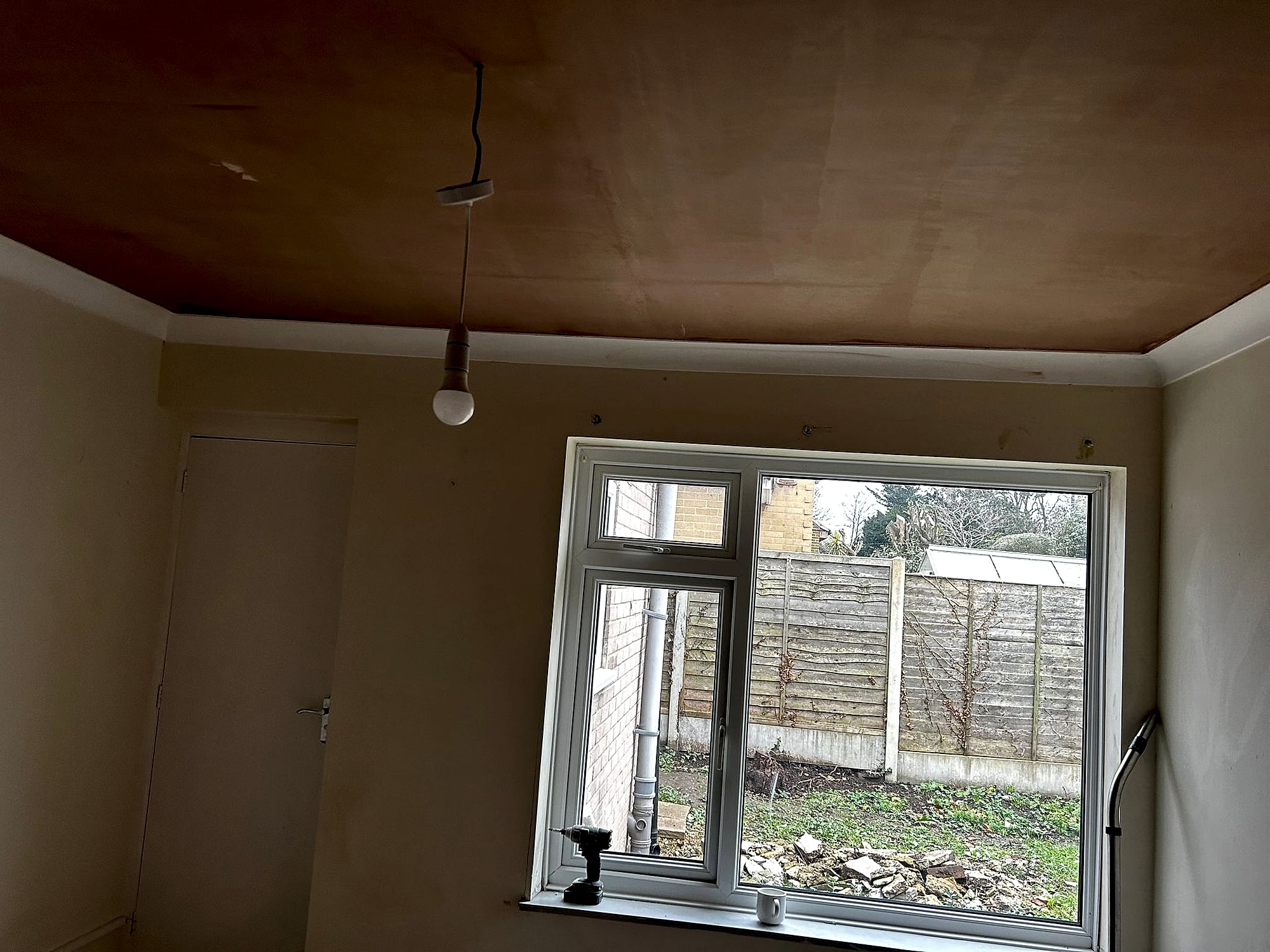 Freshly skimmed ceiling with recessed spotlights drying showing smooth plaster finish in Kent room