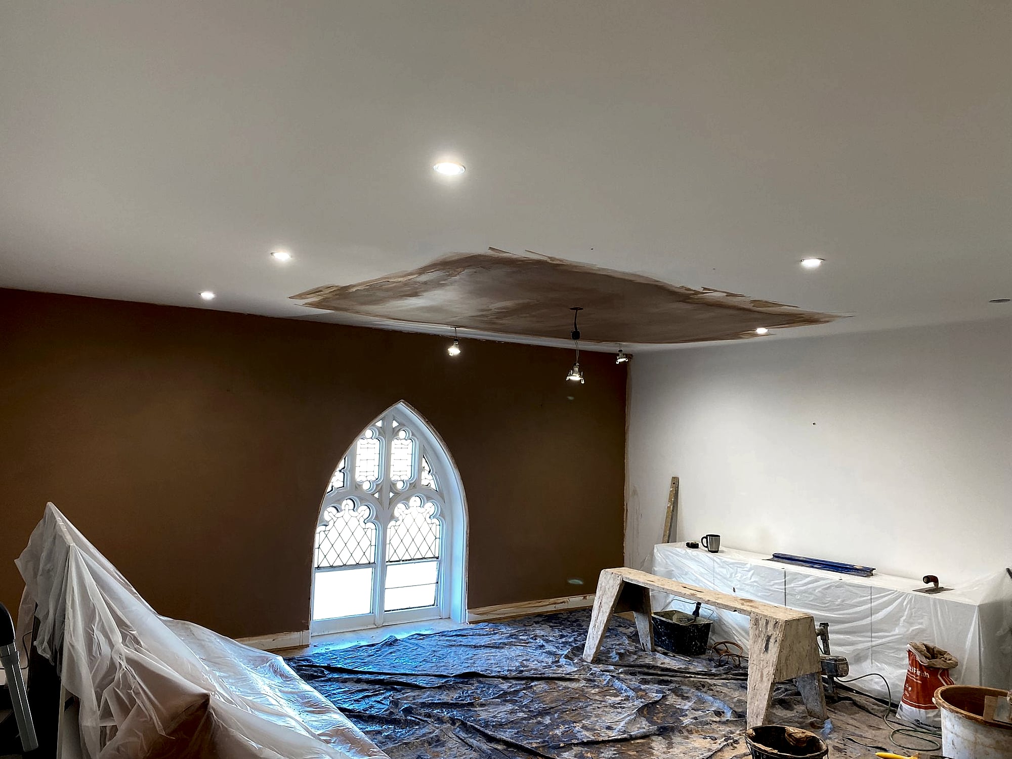 Church conversion ceiling plaster repair with patch being skimmed around spotlights and gothic window in Broadstairs