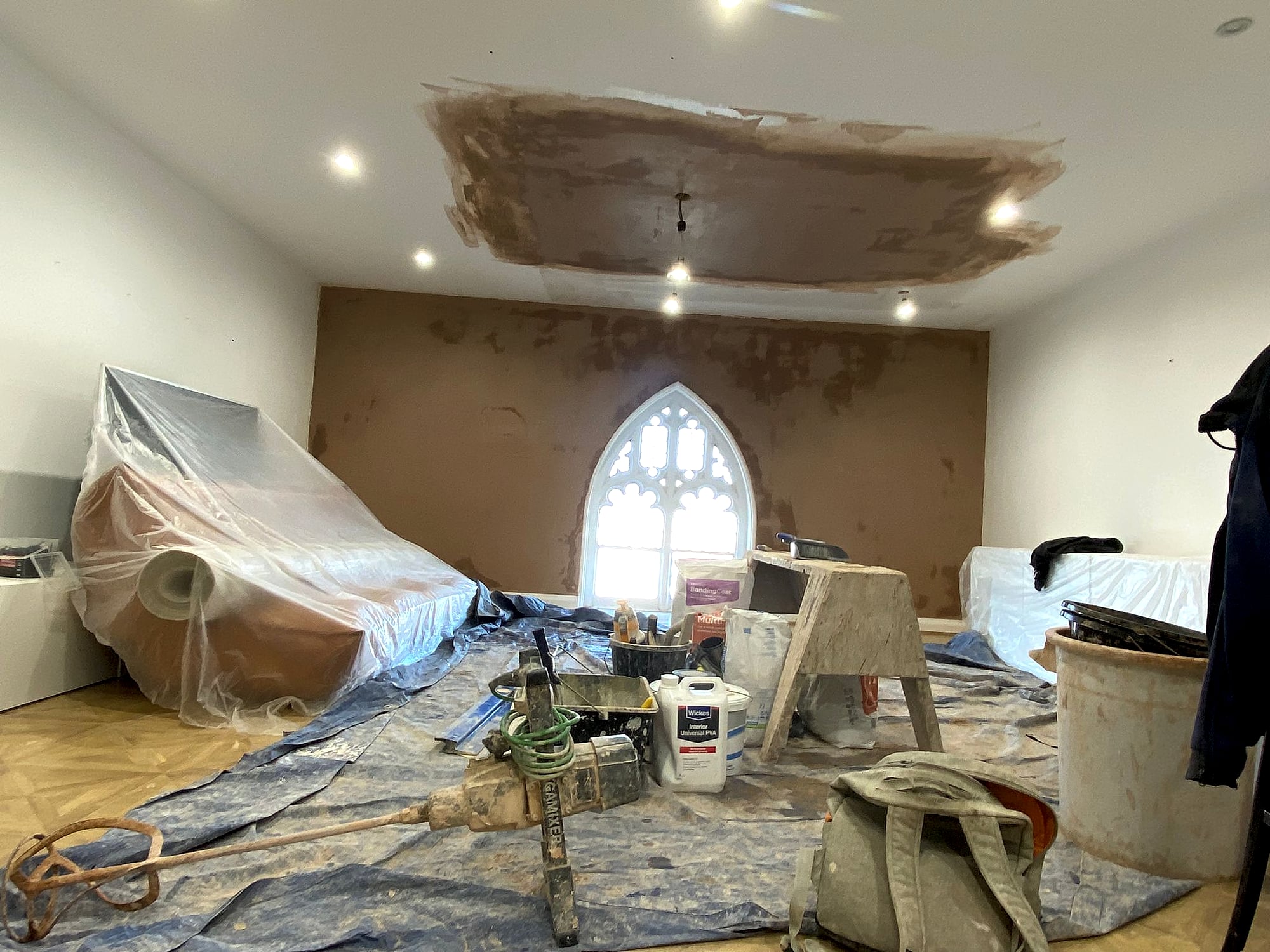 Church conversion plastering in progress with ornate gothic window and fresh skim coat on ceiling in Broadstairs