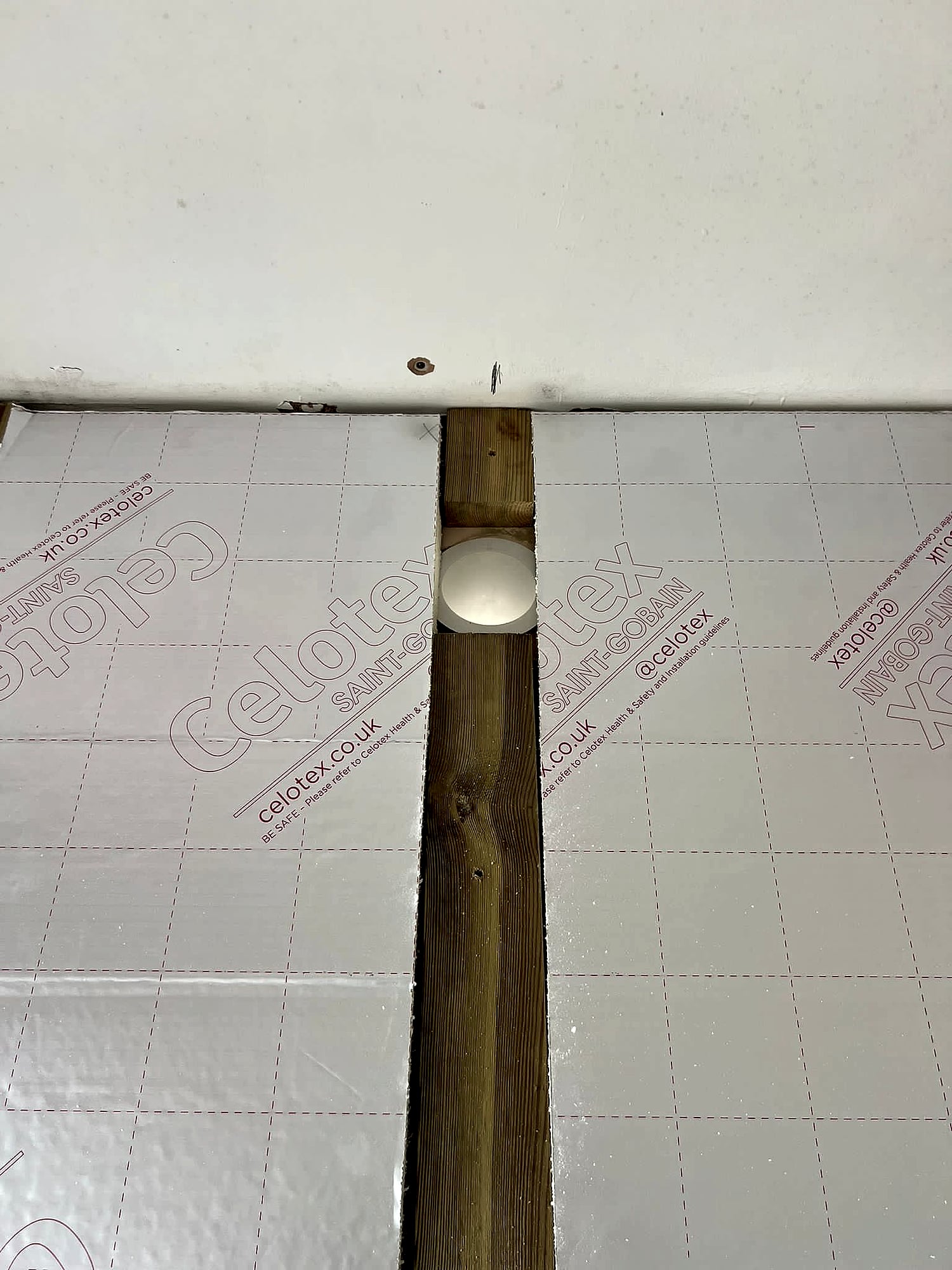 Small room dry lined with green moisture-resistant plasterboard around window and ladder in Broadstairs property