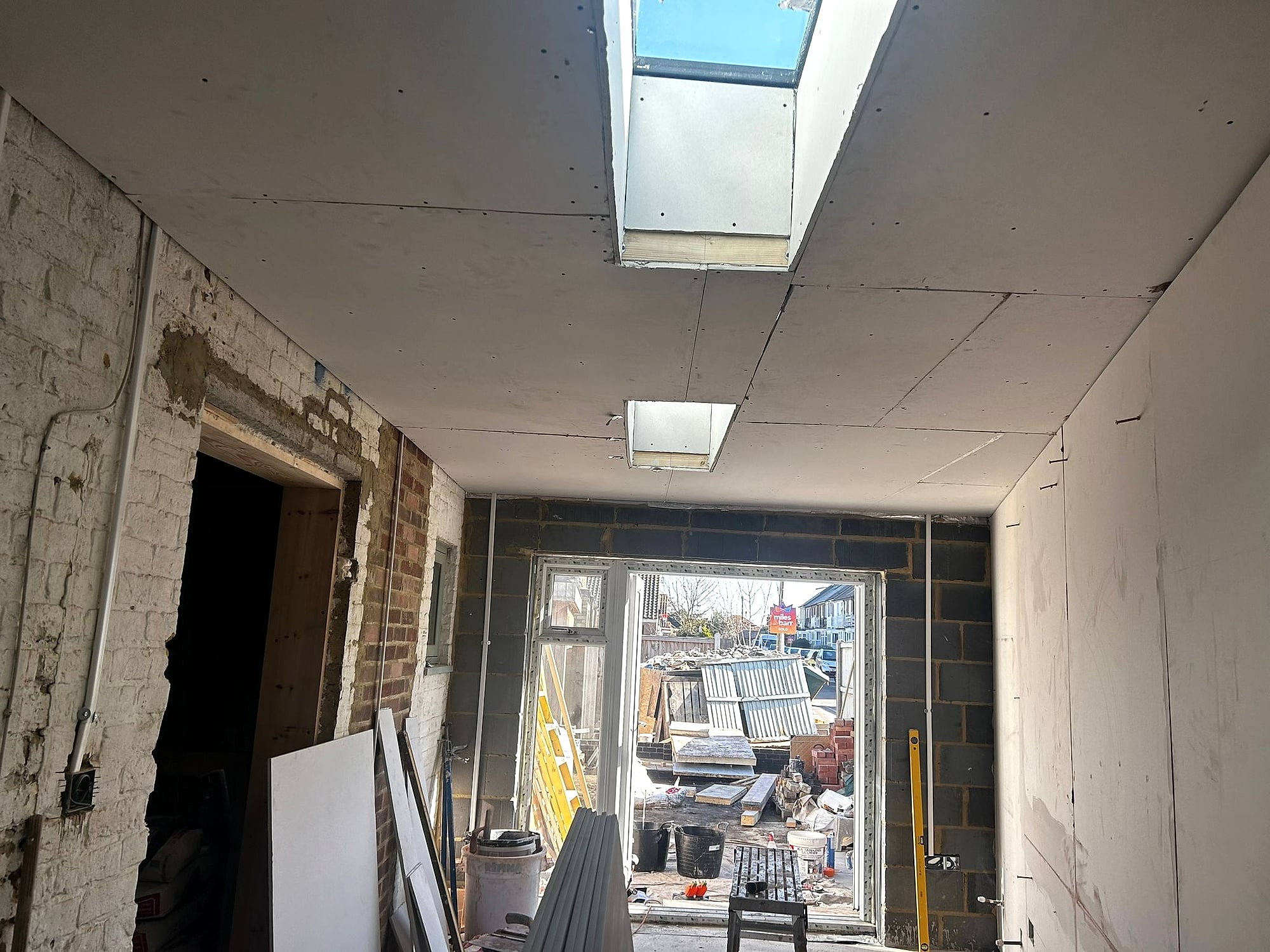 Extension plasterboard ceiling with skylight and blockwork walls during dry lining project in Kent home