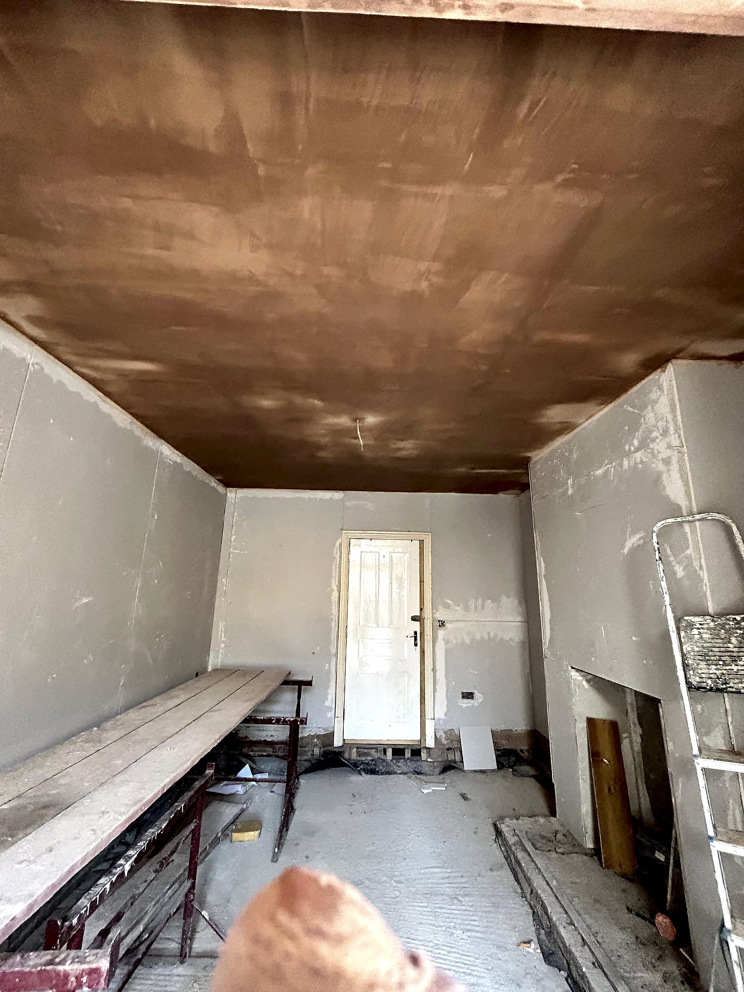 Extension ceiling freshly skimmed with two skylights and plasterboard walls during renovation in Kent