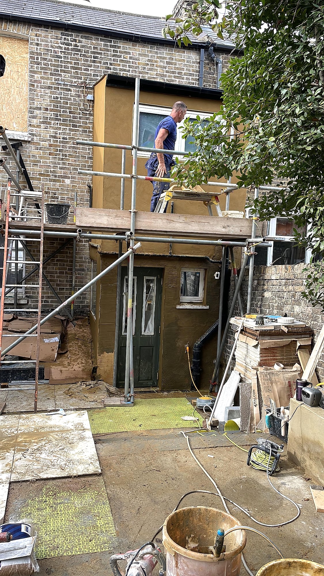 Period property with fresh render next to traditional Kent flint wall showing completed exterior finish