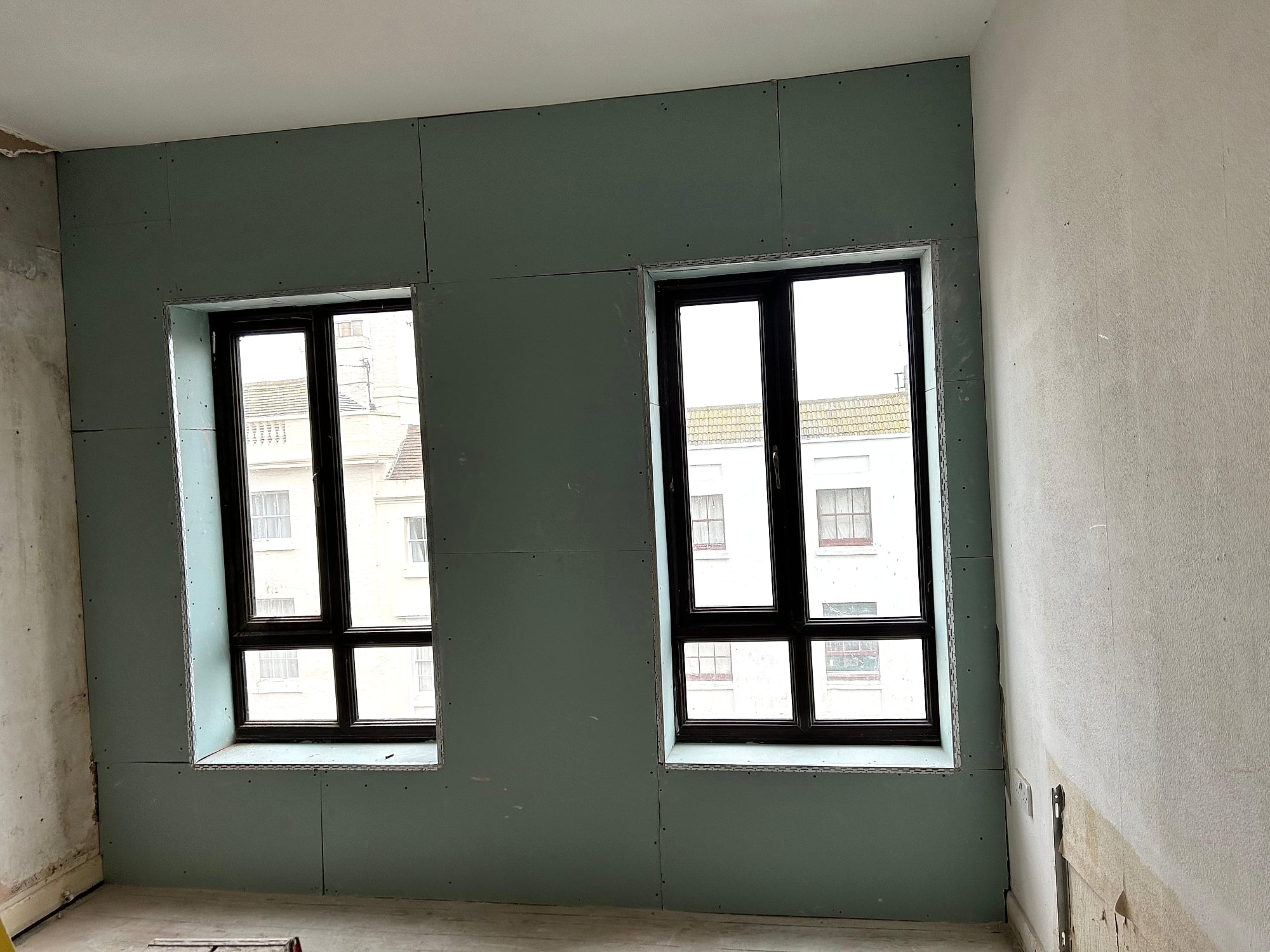 Green moisture-resistant plasterboard dry lining fitted around bay windows in period Kent property