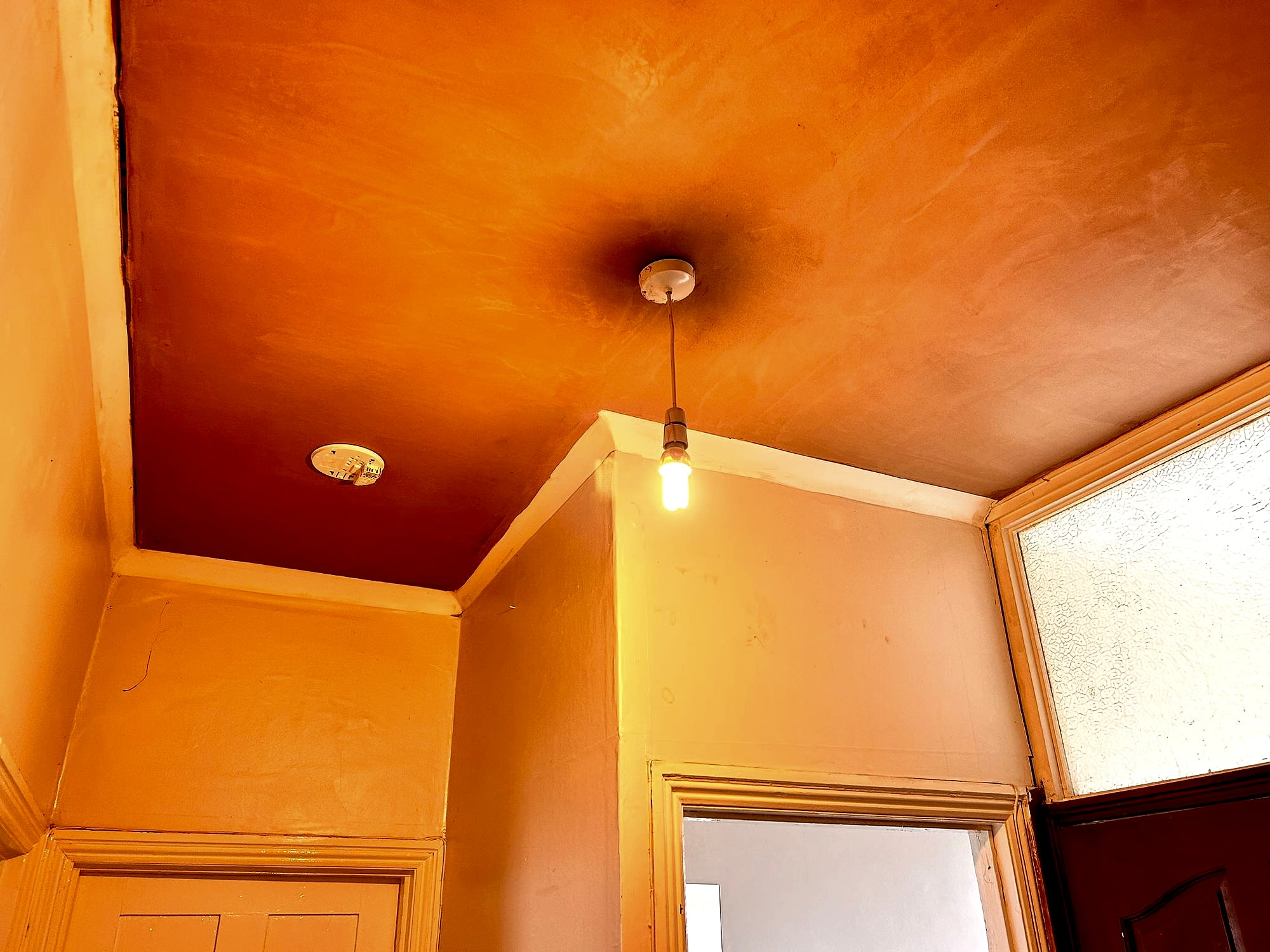 Hallway ceiling freshly skimmed showing smooth plaster finish with pendant light and coving in Kent property