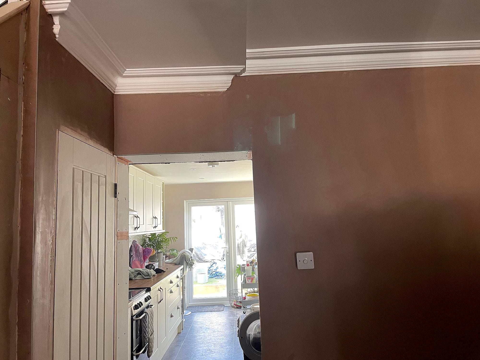 Freshly plastered hallway with coving looking through to kitchen showing smooth walls in Kent property