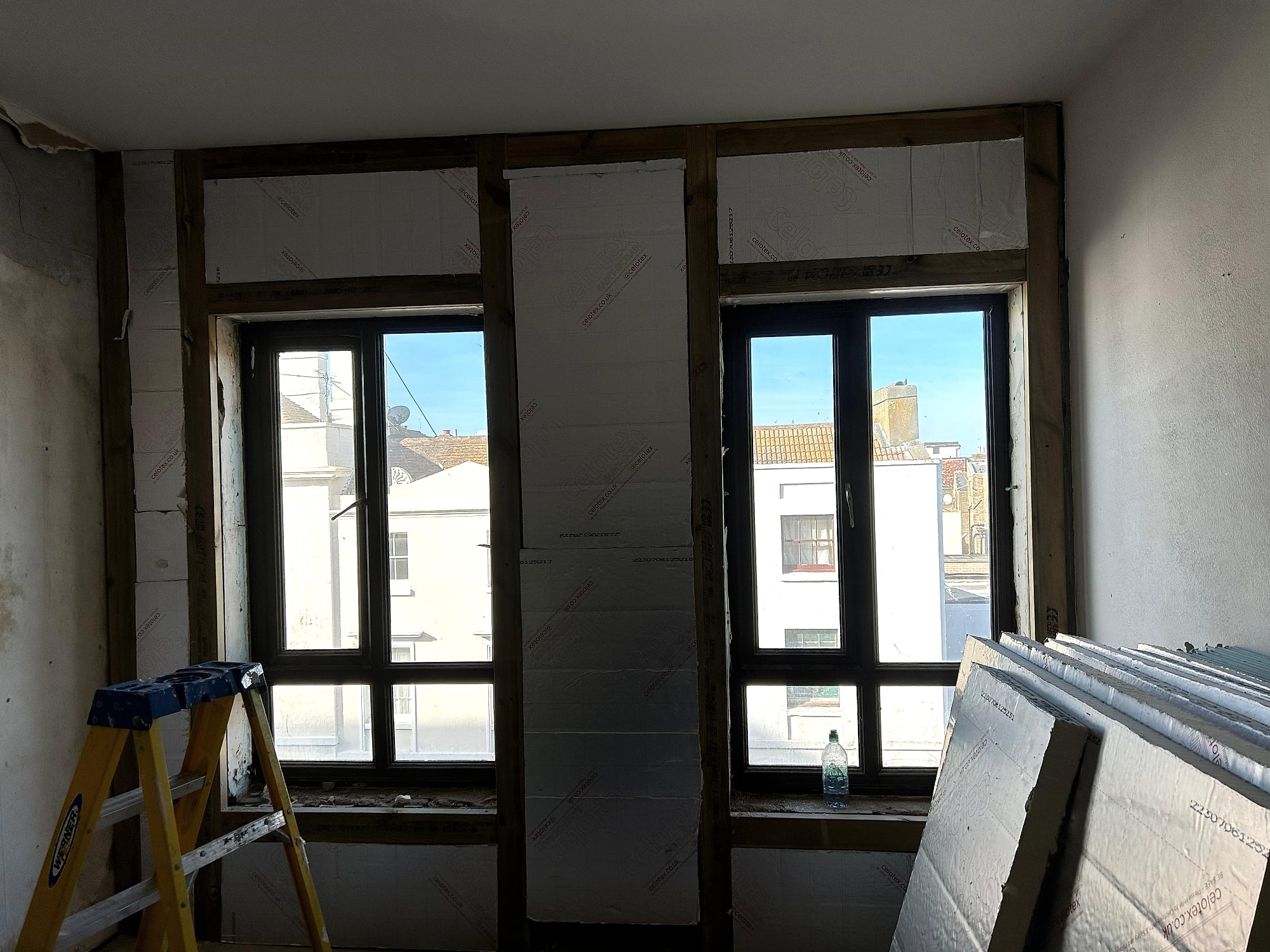 Hallway wall plaster repair in progress showing fresh wet plaster next to front door in Kent home