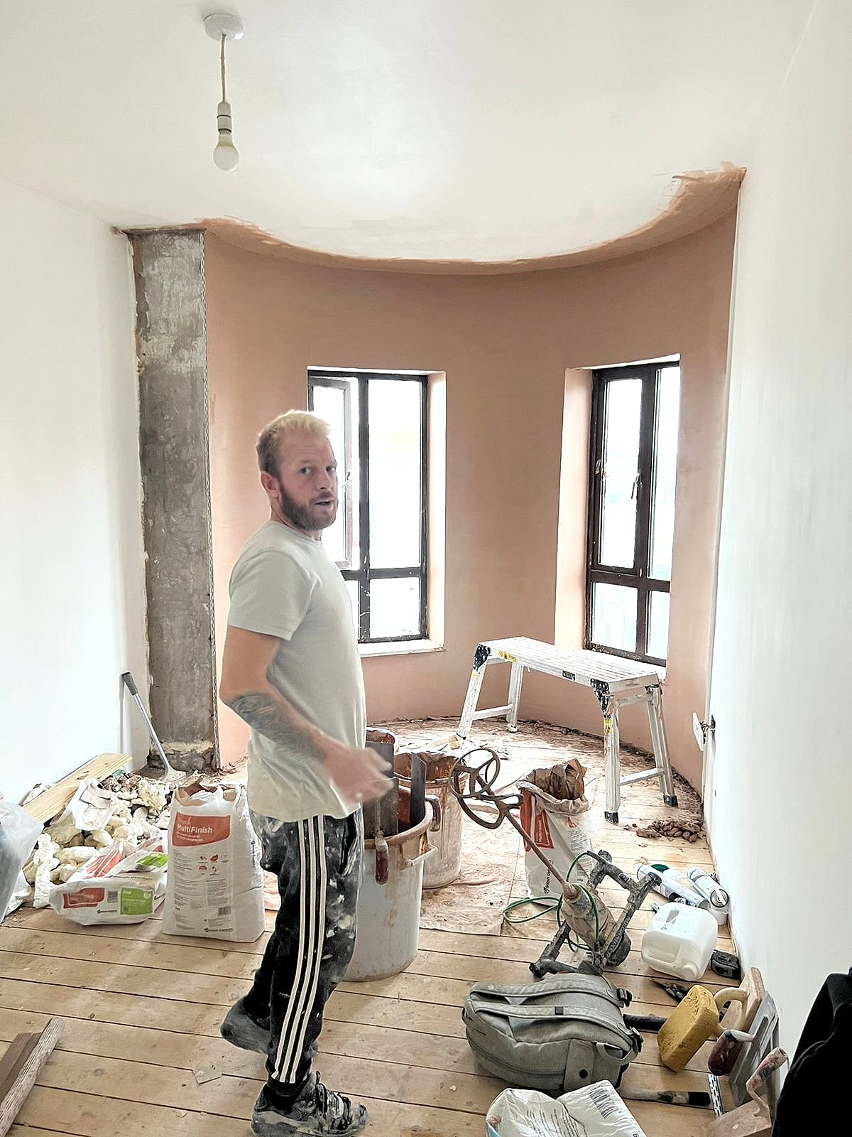 Lee Wehrle plastering curved bay window reveal with fresh skim coat and tools in Broadstairs period property