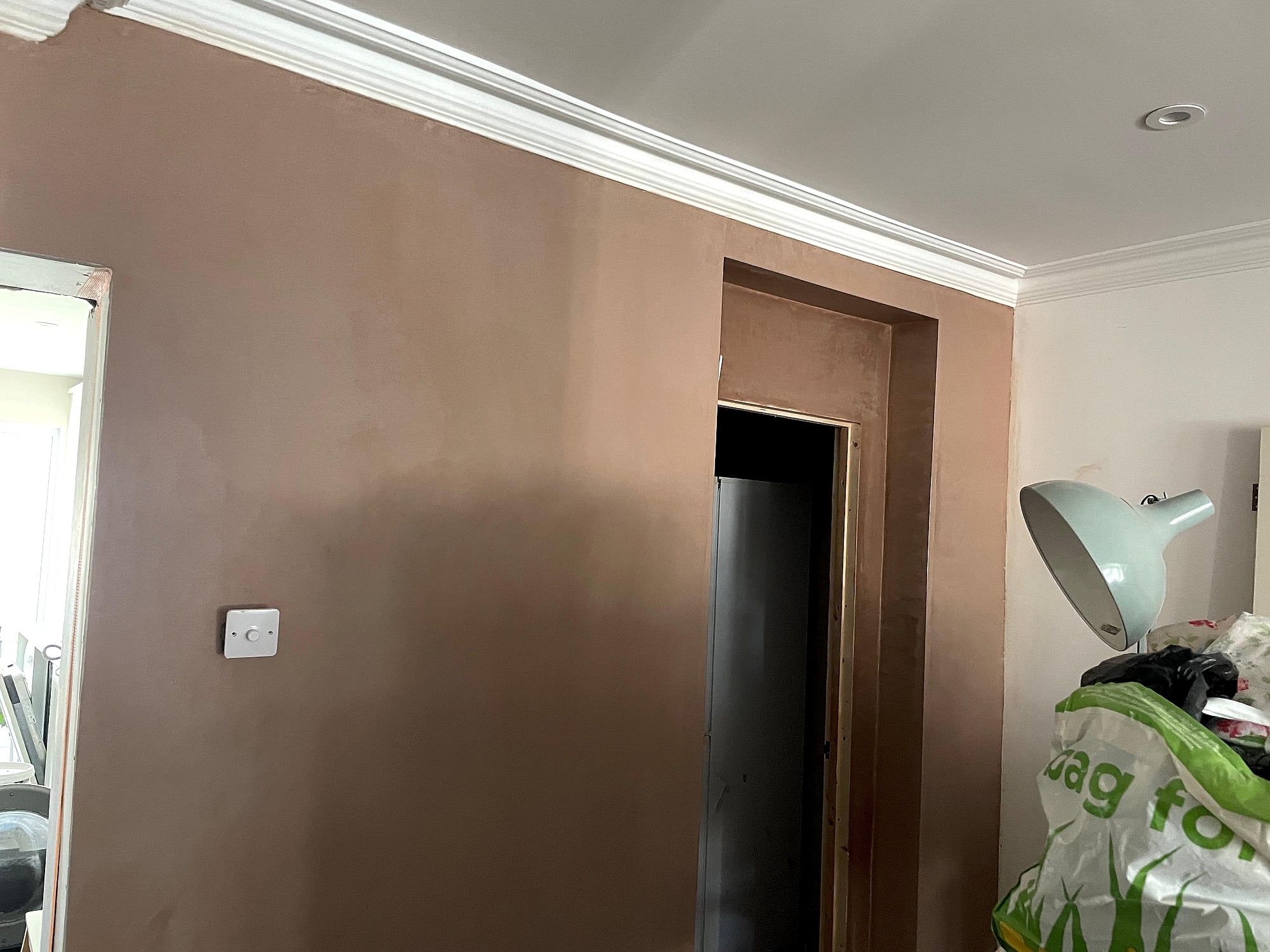Living room freshly plastered with decorative coving and neat doorway plaster finish in East Kent home