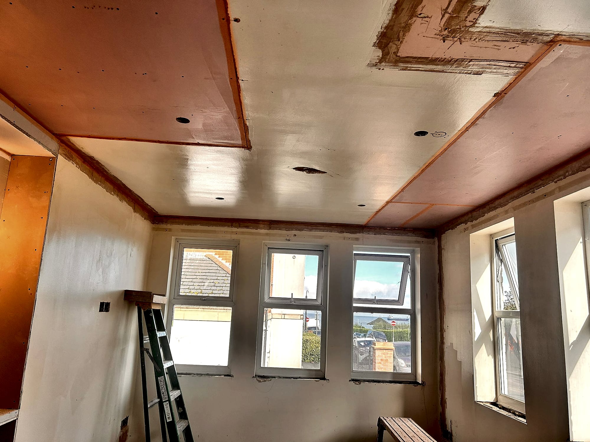 Lowered plasterboard ceiling with boarding detail in bedroom showing neat screw pattern in Kent home