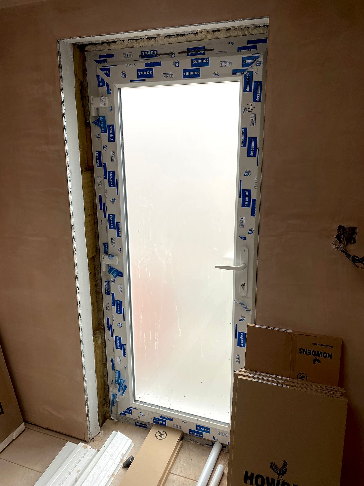 Freshly plastered walls around newly fitted door in kitchen extension renovation in Kent property