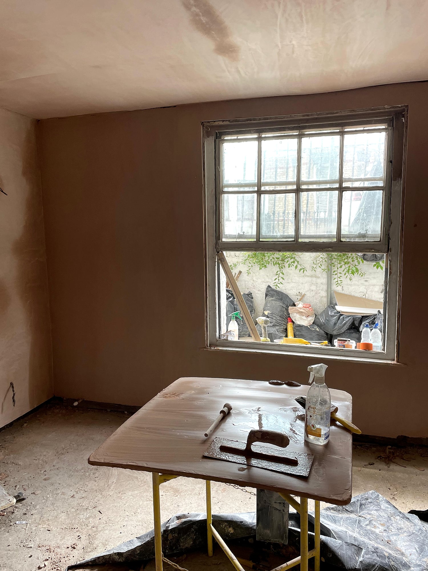 Period property room freshly plastered with sash window and plastering tools on workbench in Kent