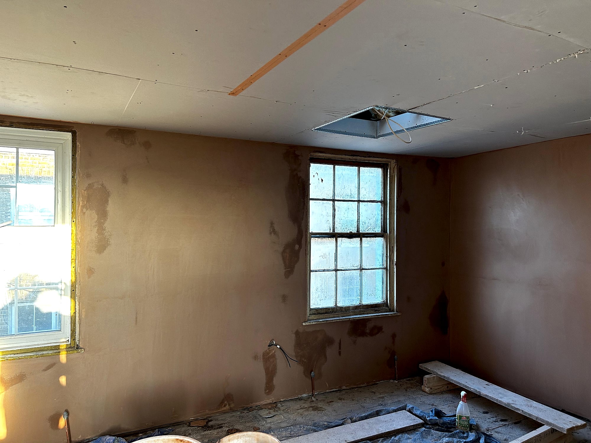 Period property room with freshly plastered walls and plasterboard ceiling with loft hatch in Kent