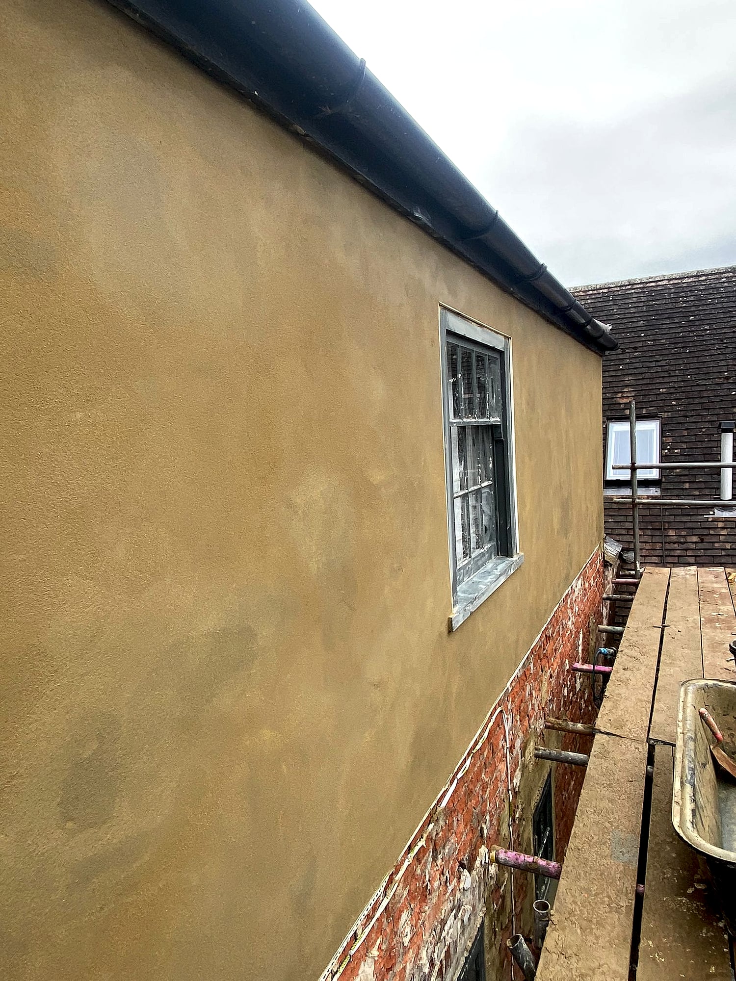 Close-up view of fresh sand and cement render from scaffolding showing smooth finish on Kent period property