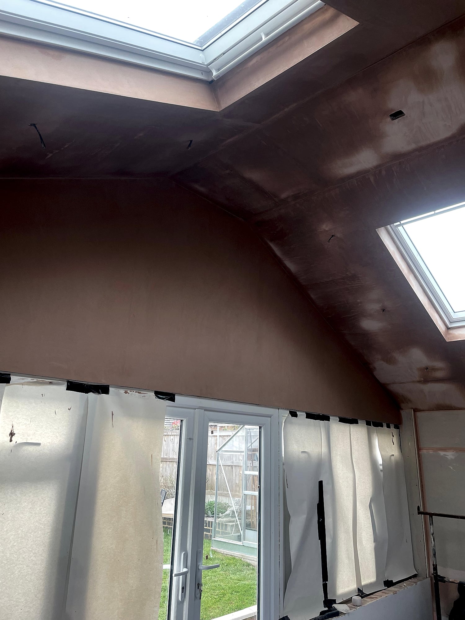 Extension plasterboard boarding in progress on vaulted ceiling with skylight before skim coat in Kent