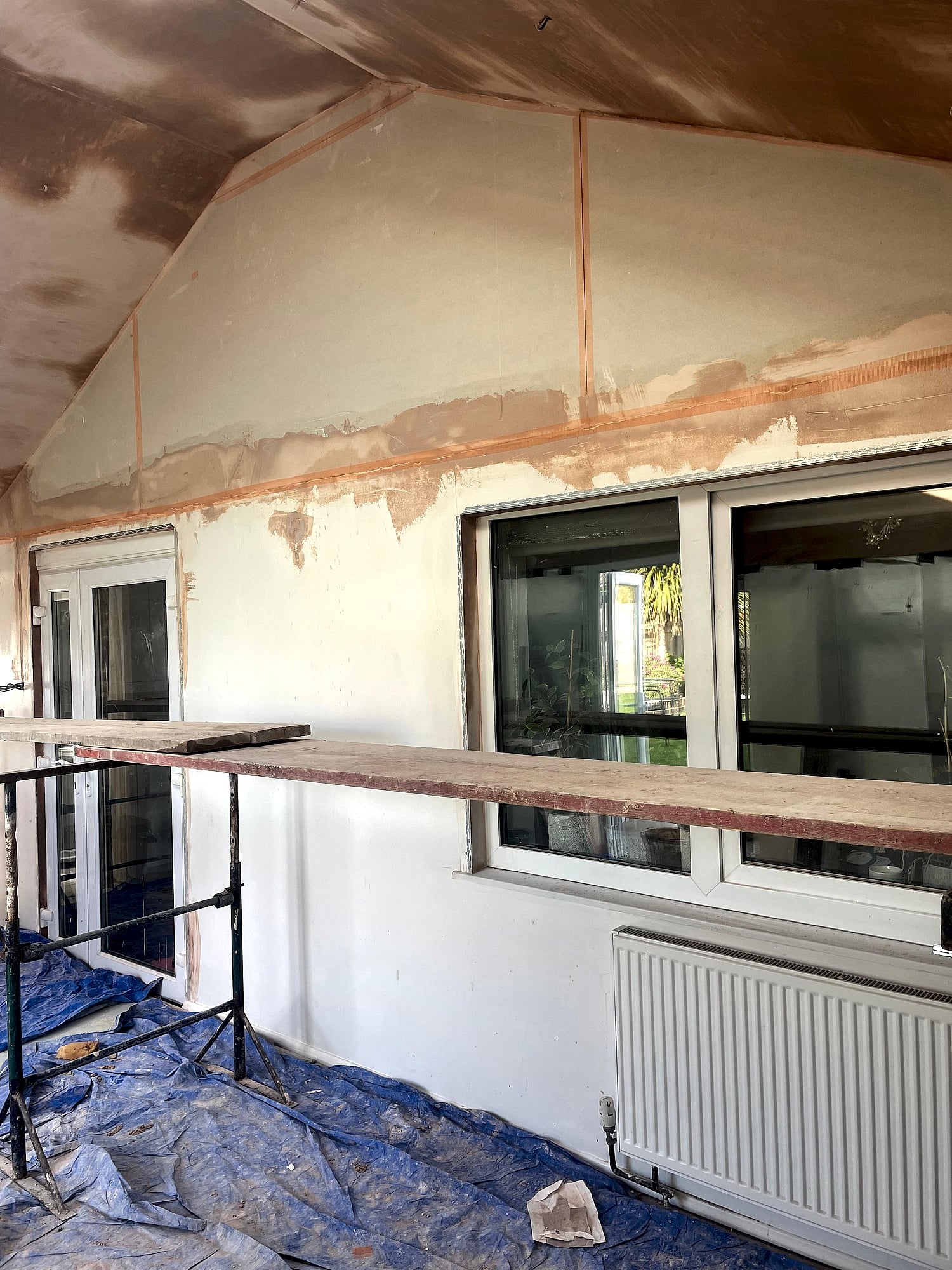 Vaulted extension ceiling freshly skimmed with dual skylights and patio doors looking onto garden in Kent