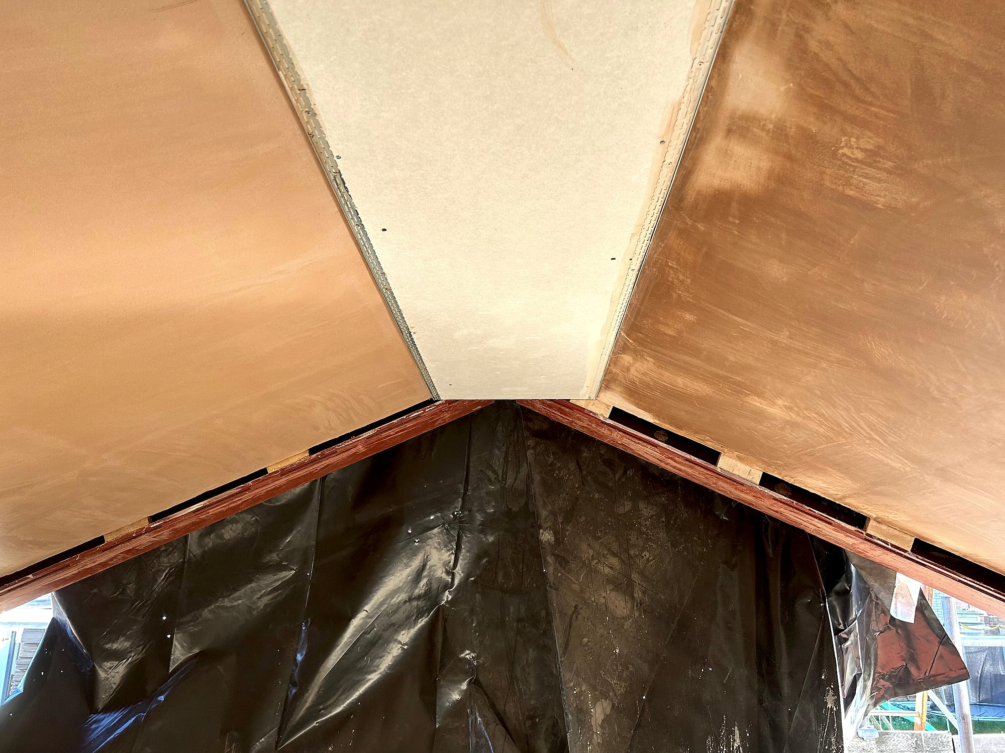 Vaulted roof section freshly skimmed from scaffolding platform during new build plastering project in Kent