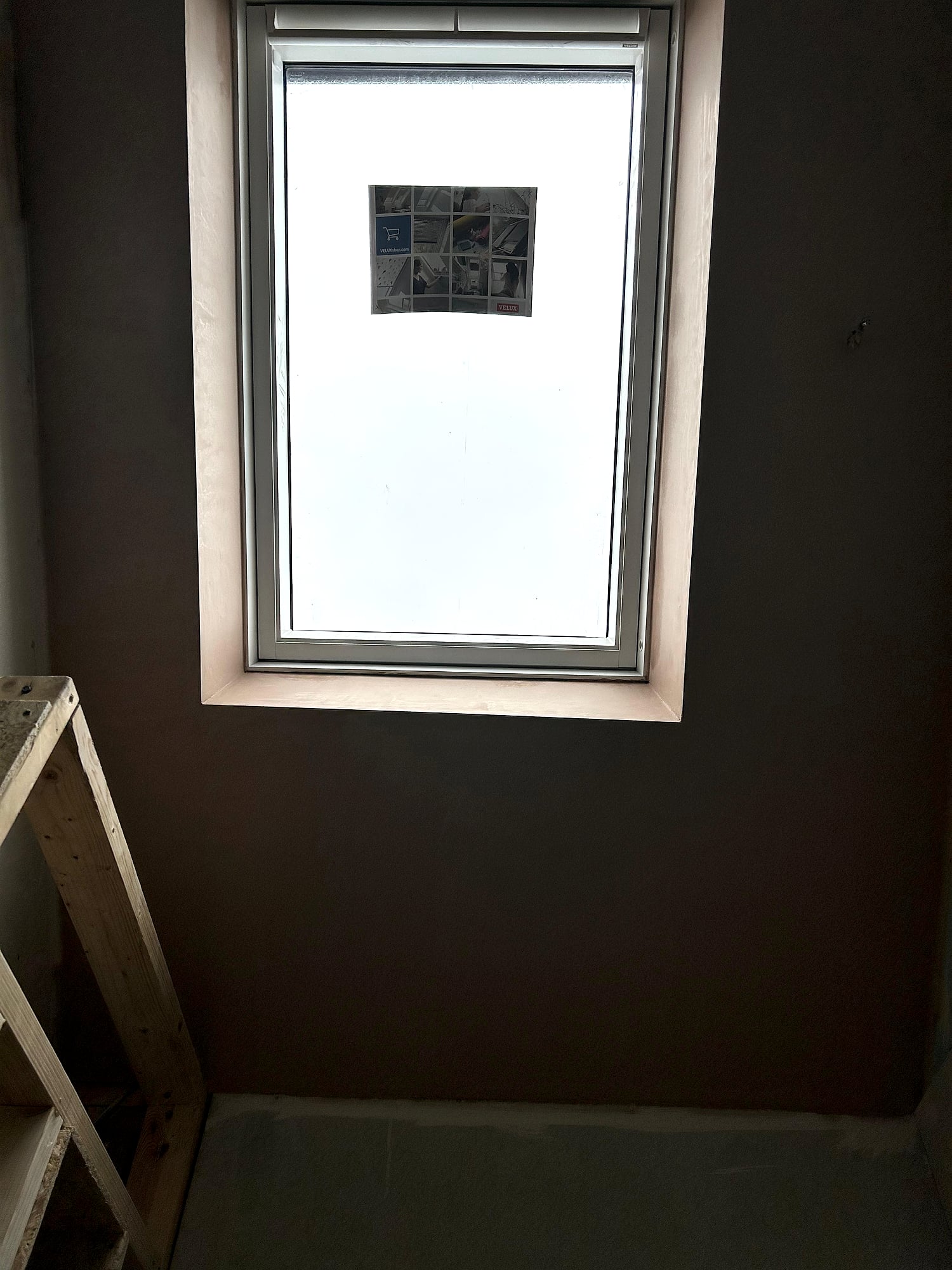 Velux skylight with freshly plastered reveal and splayed sides in loft conversion in East Kent property