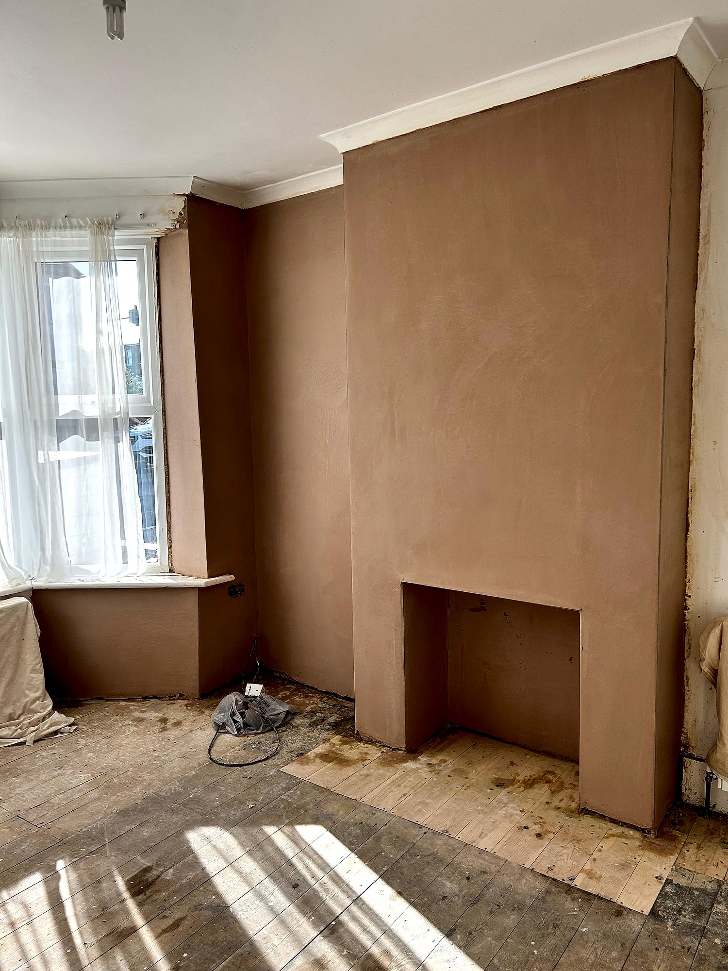Victorian chimney breast and fireplace opening freshly plastered with smooth skim coat in period Kent home
