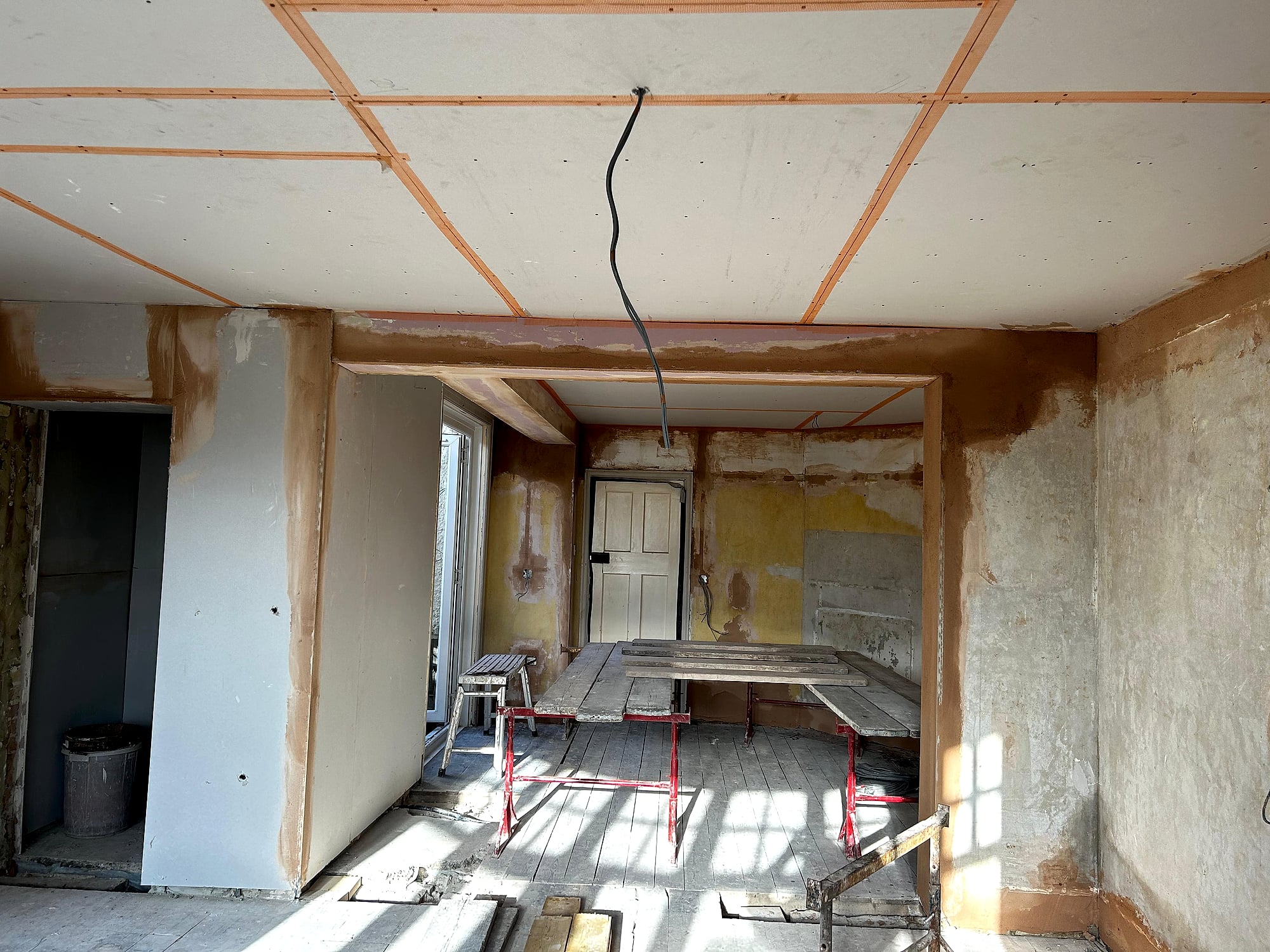 Large Victorian room with new plasterboard ceiling fitted above stripped walls ready for plastering in Kent