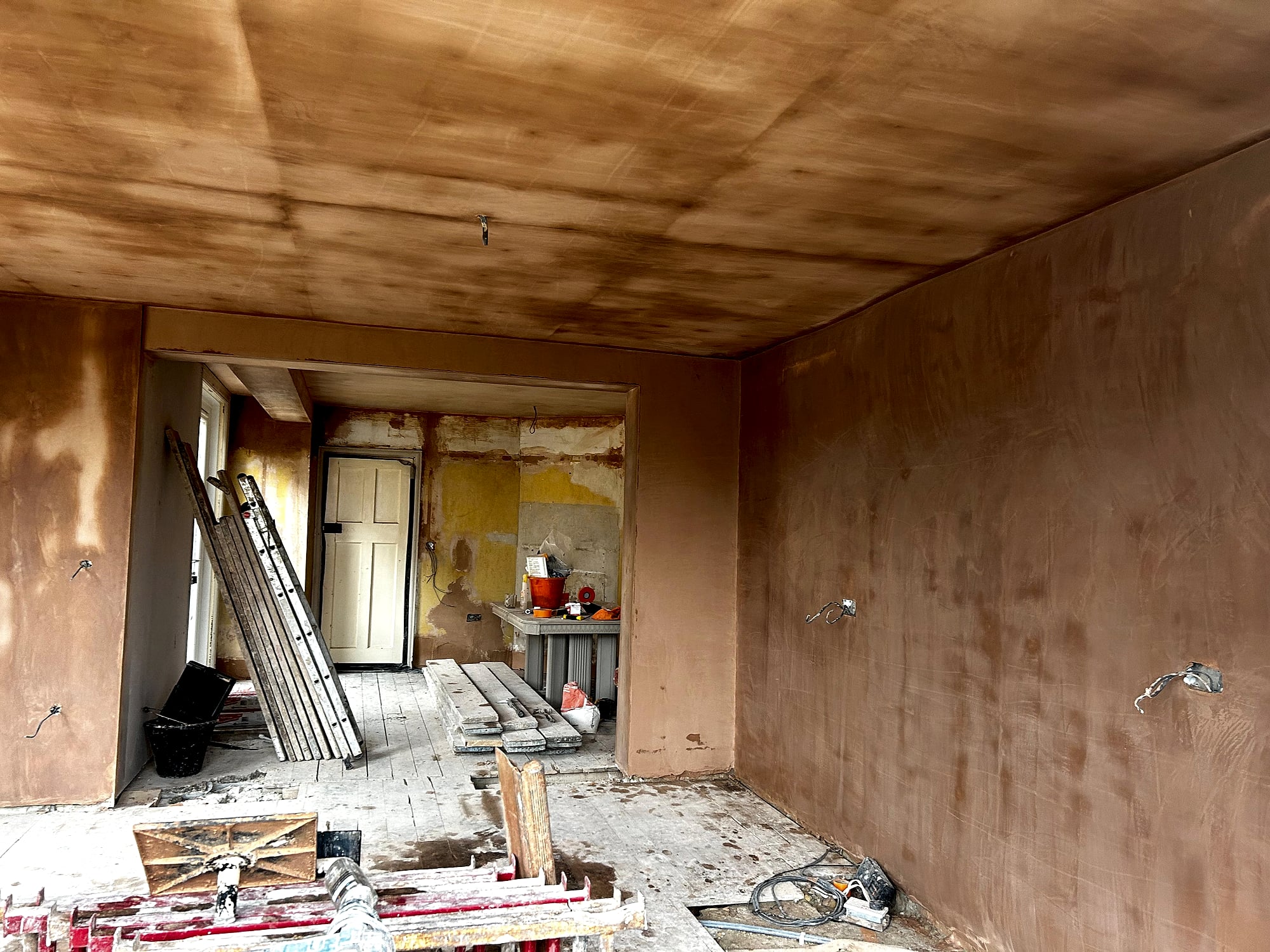 Full room plastering in progress showing fresh skim coat on walls and ceiling of Victorian house in Kent