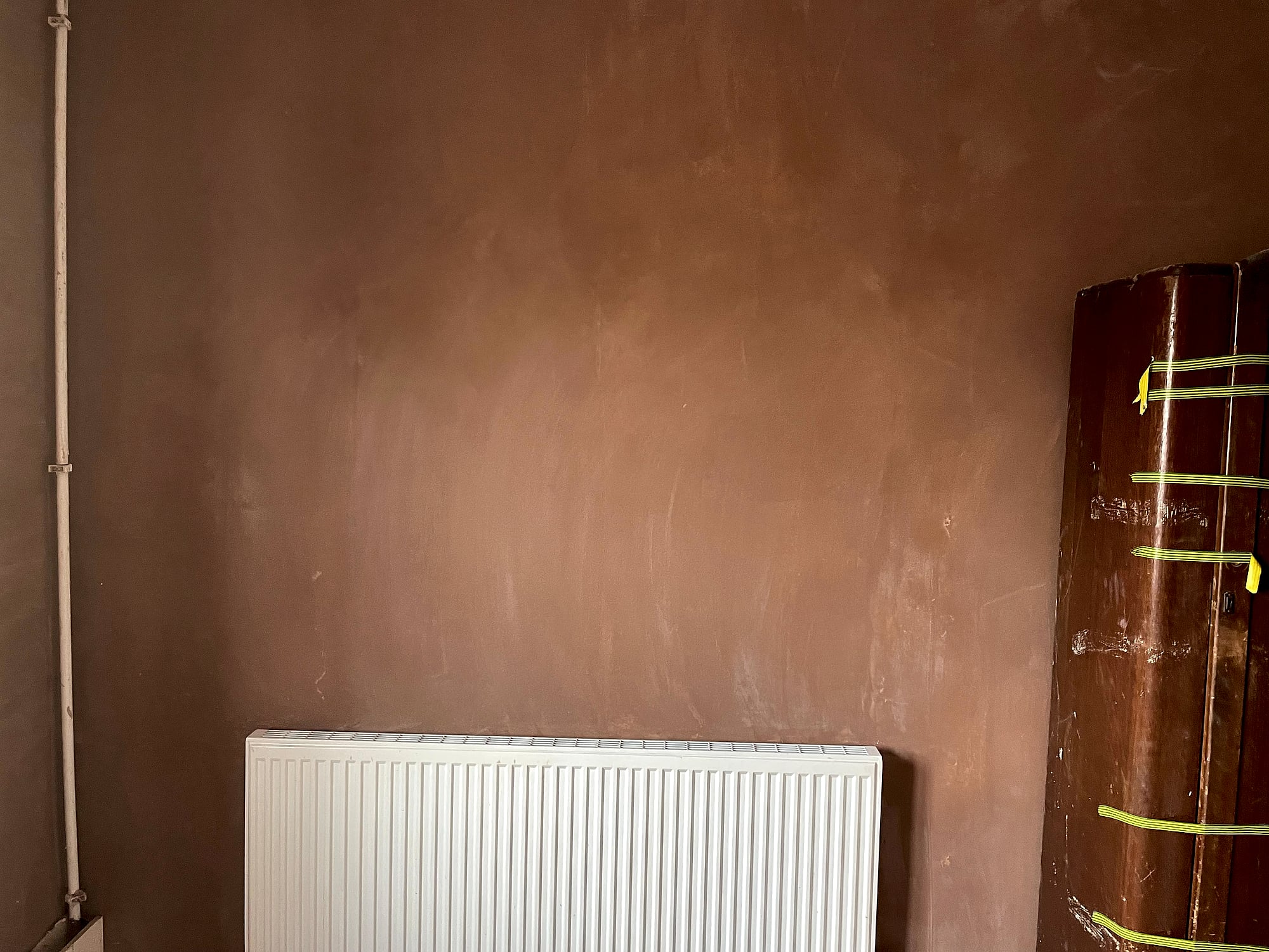 Freshly skimmed wall with smooth plaster finish beside radiator in period property renovation in East Kent